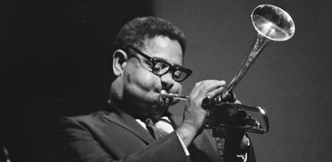 Dizzy Gillespie med bøjet trompet og runde basunkinder.