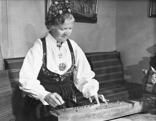 Barbro Myhre (1893-1978) fra Valdres, et område i Norge med en ubrudt tradition for at spille langeleik. Billedet er taget i 1957.